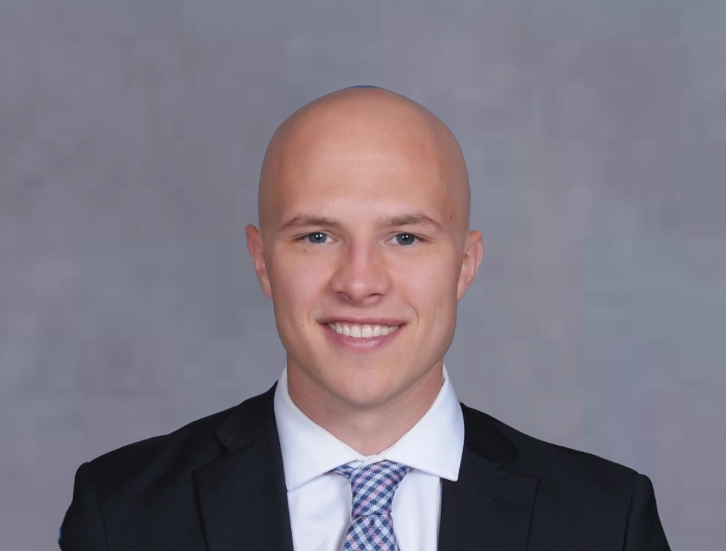 Staff headshot of Nick McClain in front of a gray background.