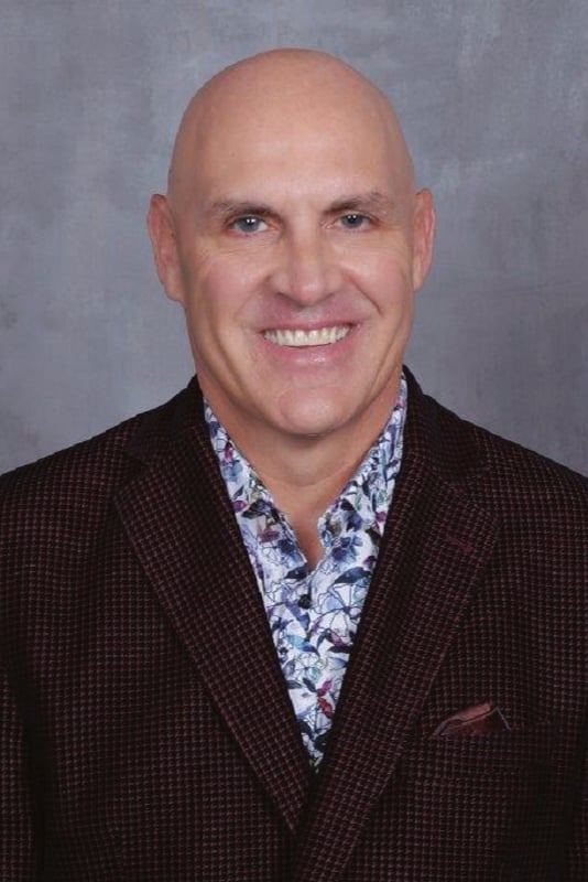 Tony McClain headshot in front of a gray background